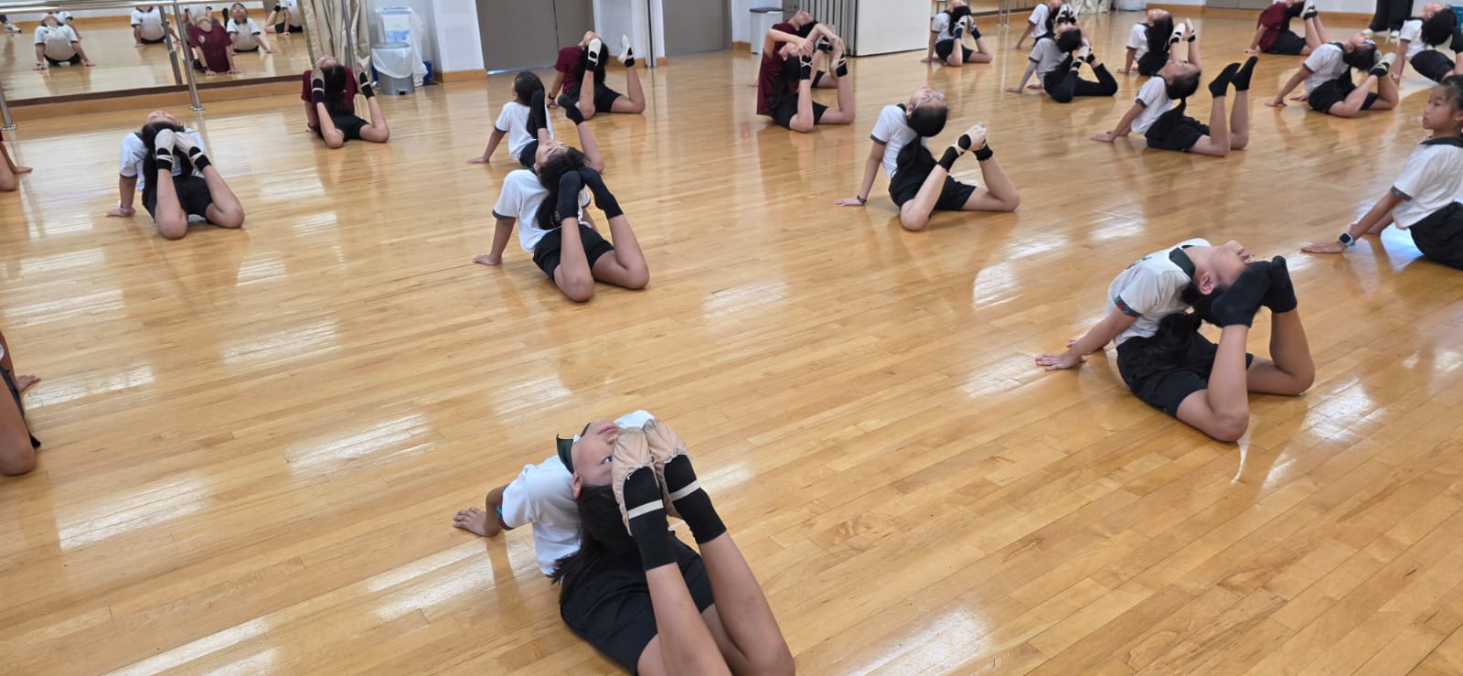 Dancers warming up their muscles through their weekly stretching routine